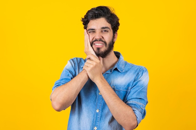 Tooth ache Young man feeling pain holding his cheek with both hands suffering from bad toothache having painful expression