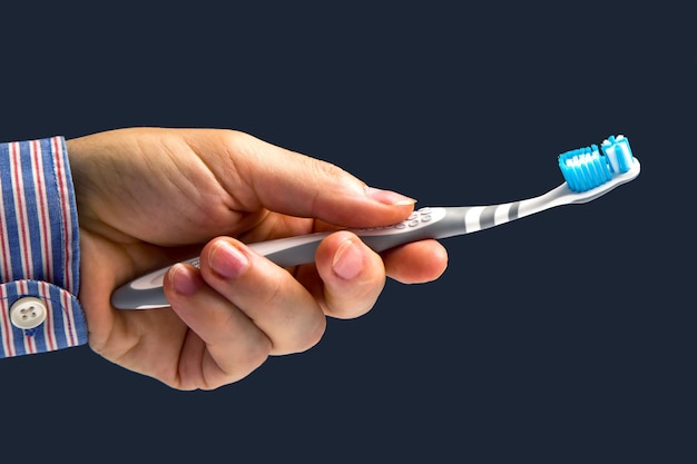 Toothbrush for cleaning teeth in hand on a dark background health items