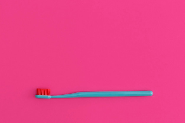 Toothbrush on a pink background with place for text