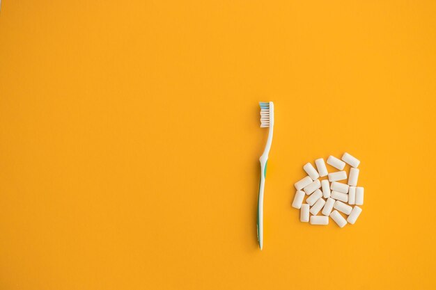 Toothbrush with chewing gum isolated on yellow background