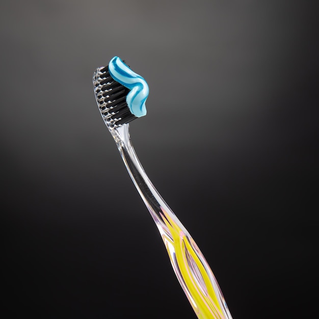 Toothbrush with toothpaste for cleaning teeth on a dark background health care health items