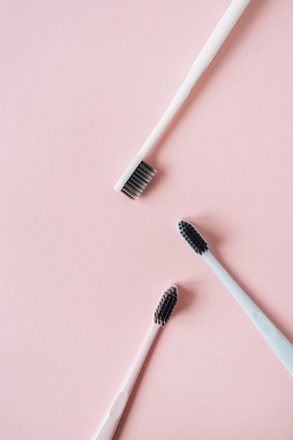 Toothbrushes on pink background. Flat lay, top view oral care, dental hygiene concept.