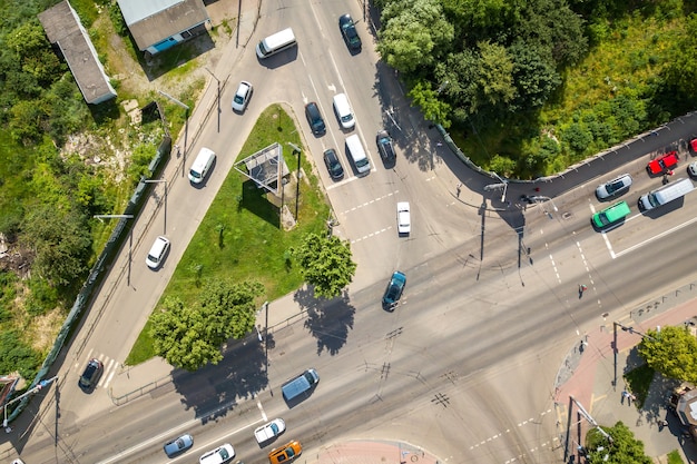 Top down aerial view of busy street intersection with moving cars traffic.