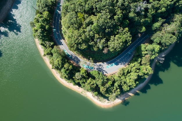 Top down from Drone aerial view of rainforest with asphalt road around the dam