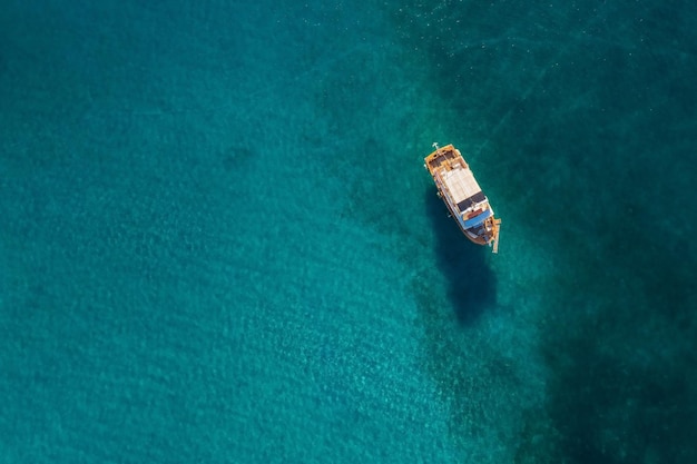 Top-down view of a boat in shallow water with shadow on the seabed, Crete, Greece