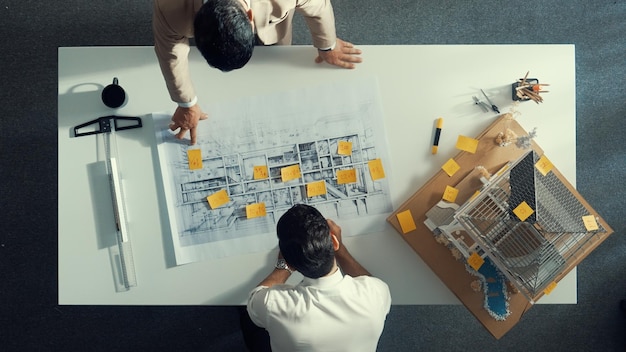 Photo top down view of team compare between blueprint and house plan alimentation