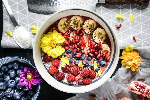 Photo top shot of a fruit cake with berries banana and pomegranate. baking process in the kitchen