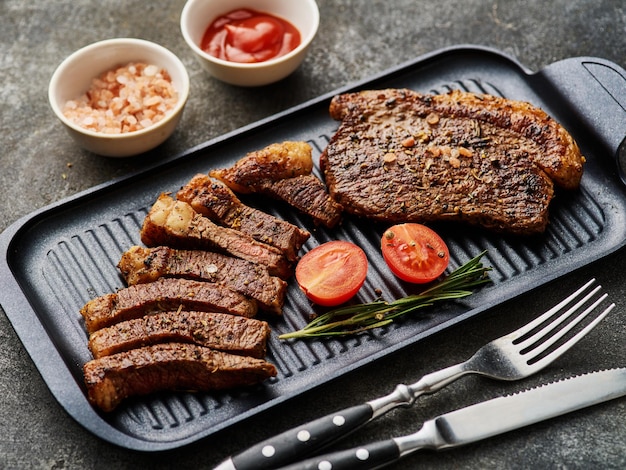 Top sirloin or cup rump steaks grilled on a black board Dark background Picanha steak