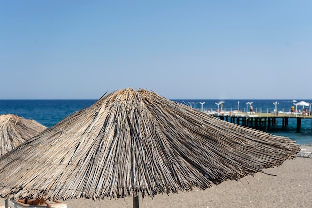 A top of the straw sun umbrella standing at the beach