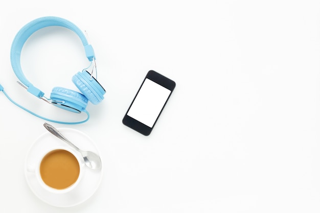 Photo top view  accessories office desk.smartphones headphones and cup of coffee on white background with copy space.