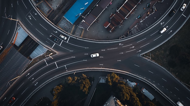 Top view aerial drone shot of asphalt road with cars in the evening city