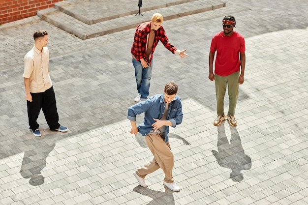 Top view at all male hiphop team performing outdoors in city lit by sunlight copy space