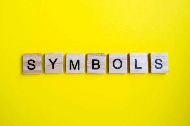 Top view of alphabet blocks with letters on bright yellow background. symbol - inscription.