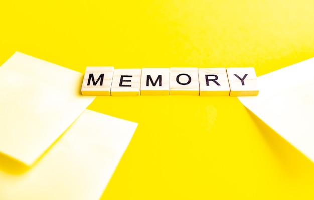 Top view of alphabet blocks with letters on yellow background. inscription MEMORY.