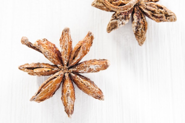 Top view: anise stars on white wooden surface close-up