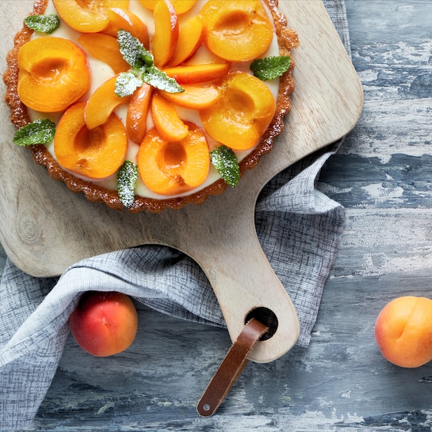 Photo top view of apricot tart with mint leaf