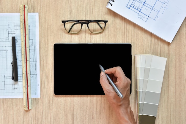 A top view of architect working desk with hand writing and draw on equipment