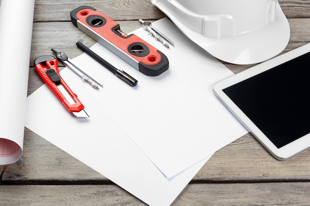 Top view of architect workplace with blueprint paper and digital tablet with blank screen