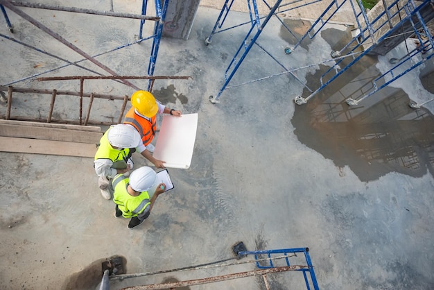 Top view of architects engineer are discussing about the progress of the building project and checking the accuracy of the building structure