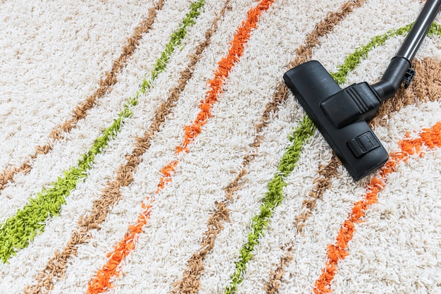 Top view arrangement with vacuum cleaner on carpet