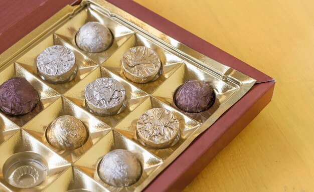 Photo top view of assorted chocolates in a box with a copy of the space