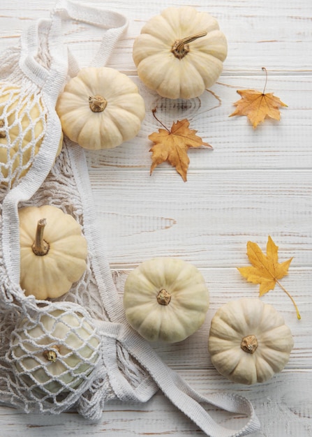 Top view autumn composition with pumpkins in mesh shopping bag