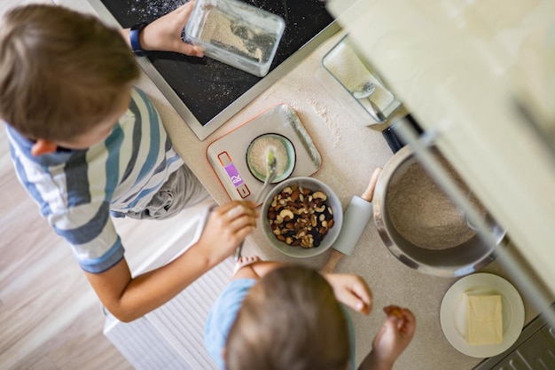 Top view baby brothers kids cooking dessert together use fresh healthy ingredients at kitchen