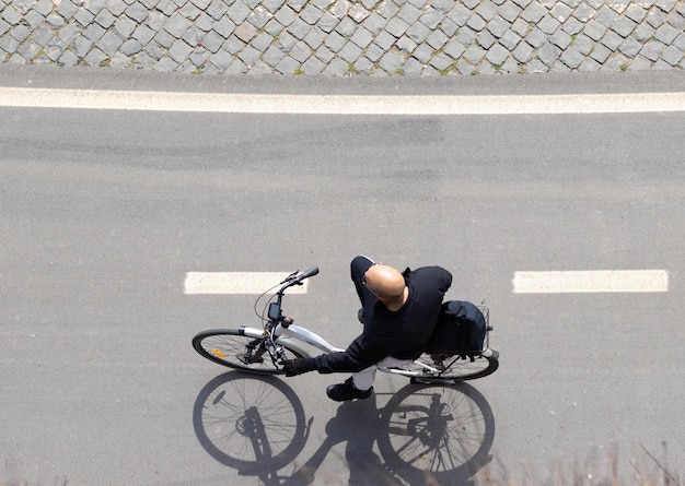 Top view of bald man riding a bike taking a walk through European city