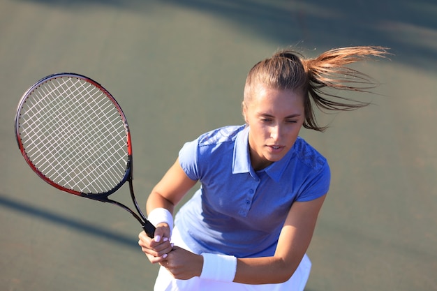 Top view of beautiful tennis player ready to serving the ball on the tennis court.