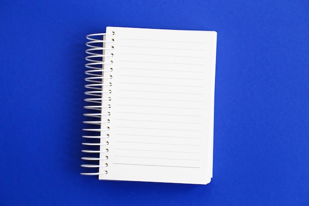 Top view of blank note paper on blue background