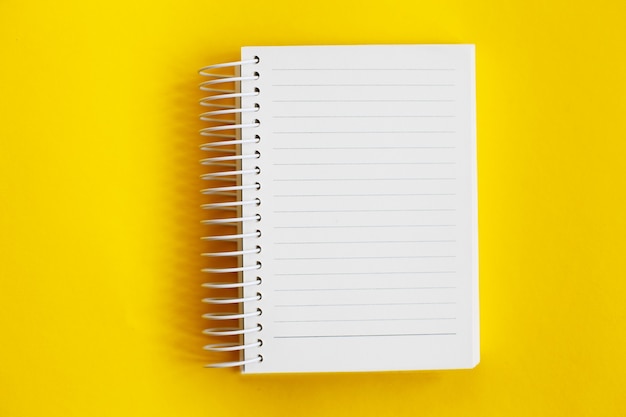 Top view of blank note paper on yellow background