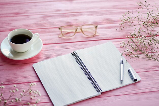 Top view blank notepad with coffee cup and glasses