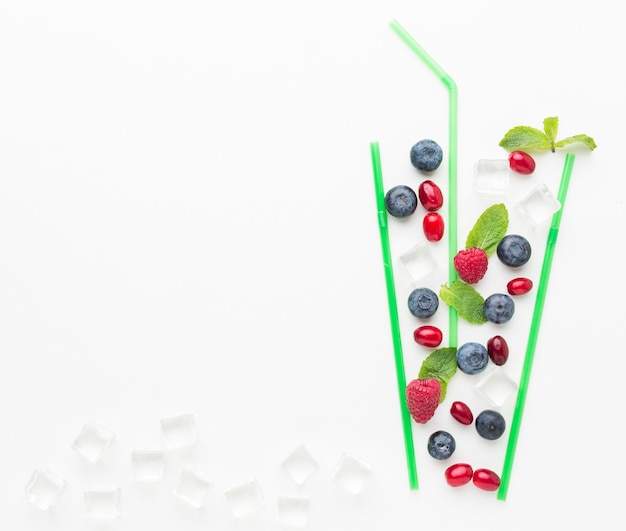 Top view of blueberries in straw glass with mint and copy space