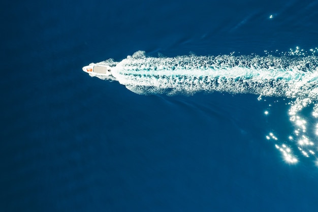 Top view of the boat or white yacht sails on the blue water of the adriatic sea