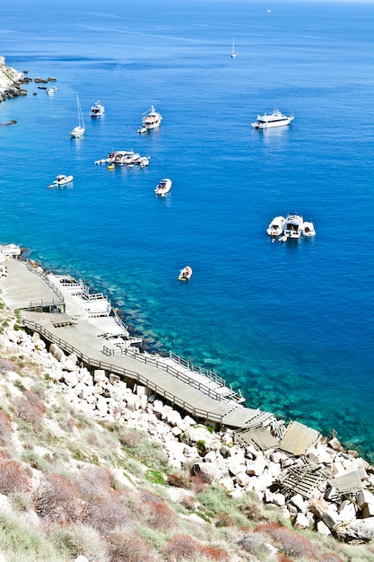 Top view on boats near a rock stone coast