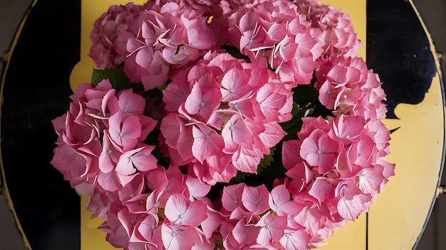 Photo a top view of a bouquet of pink hydrangeas on a black and yellow surfac