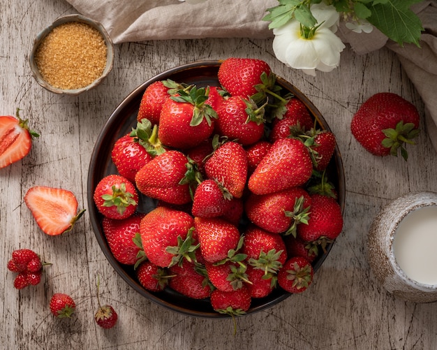 Top view of bowl with strawberry on wooden table