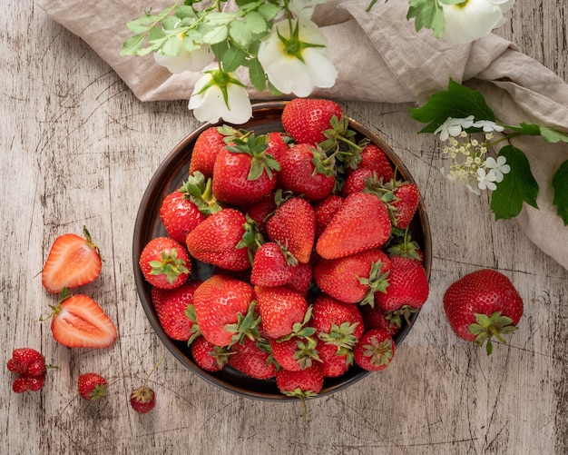 Top view of bowl with strawberry on wooden table