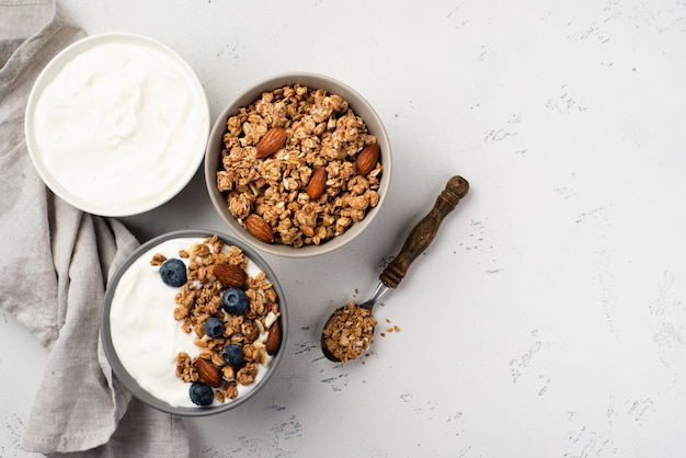 Top view of bowls with breakfast cereal and yogurt