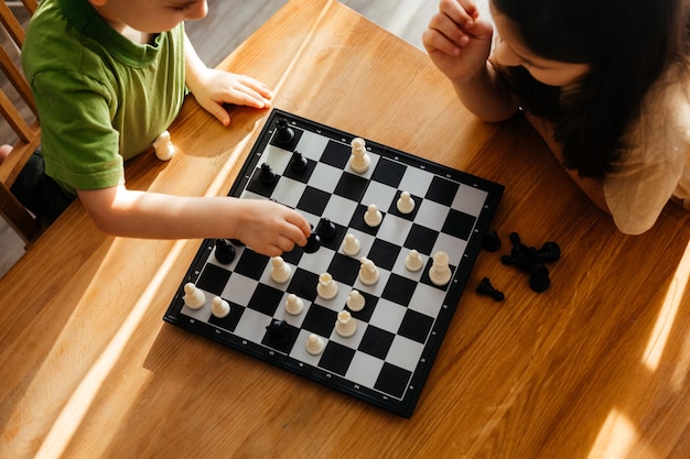 Top view boy and girl playing chess