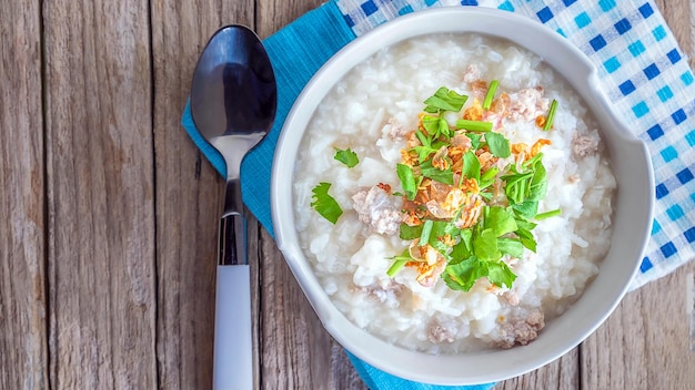 Top view of Breakfast menu boiled rice with hot minced pork and served on wooden background