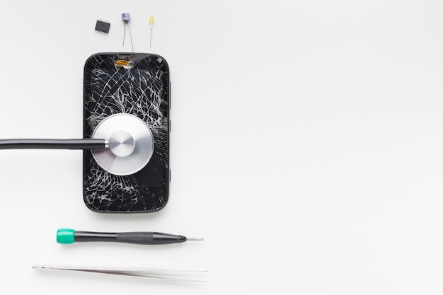 Top view broken smartphone with repair tools