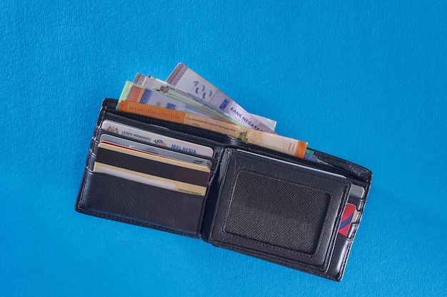 Top view of brown color wallet on blue background