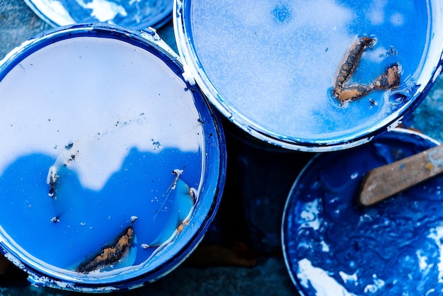 Top view of bucket with blue paint and brush