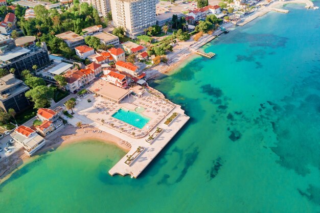 Top view of building and area with a swimming pool and sun loungers near the sea