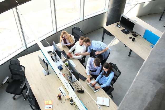 Top view of buiness team brainstorming while sitting at the office table together.