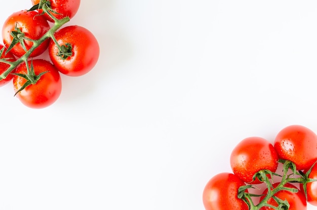 Top view of bunch of fresh tomatoes on white background