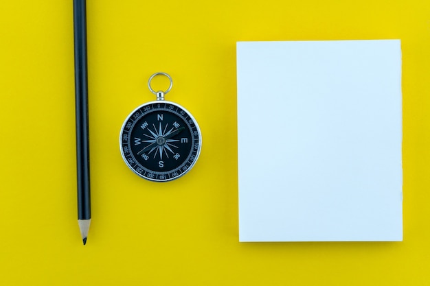 Top view business objects of white paper,pencil,and compass on paper work yellow background Flat lay composition.