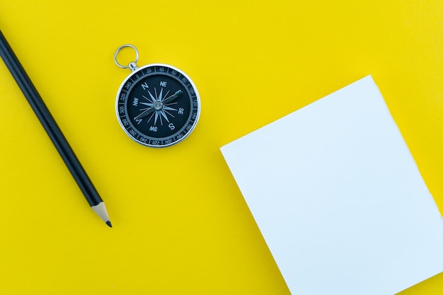 Top view business objects of white paper,pencil,and compass on paper work yellow background Flat lay composition.