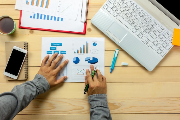  Top view business person discussing charts and graphs on office desk.